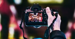 A photographer captures bustling Beijing nightlife with a camera, focused on vibrant street scenes.